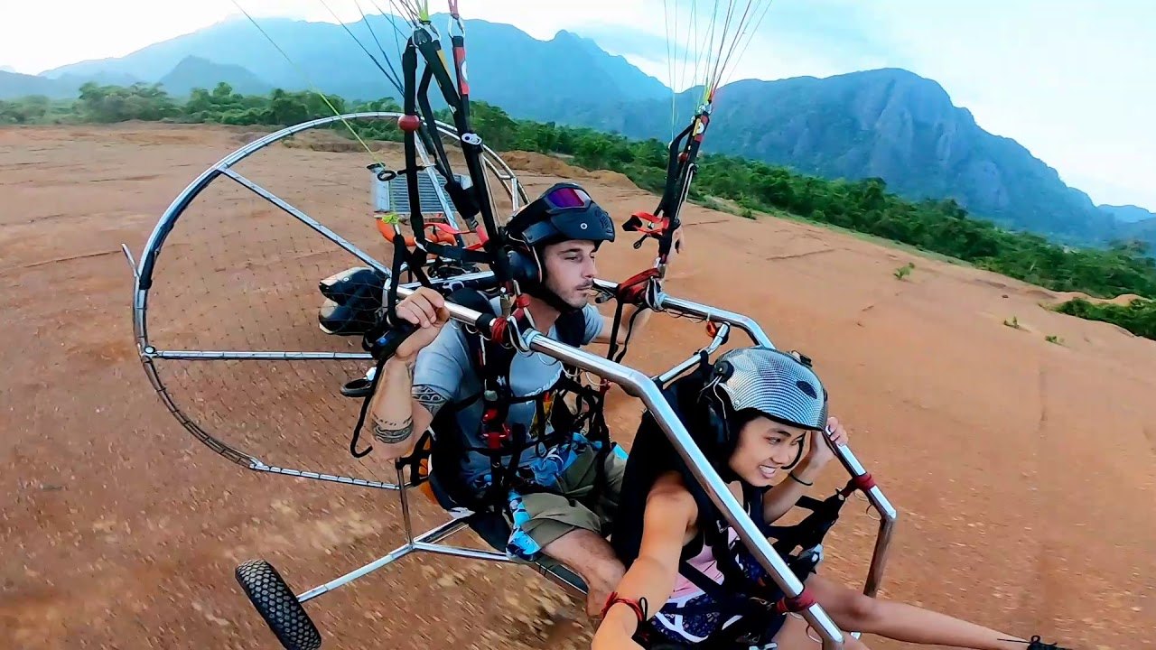 Tandem paramotor flight over Vang Vieng karst mountains operated by Terra Lao Adventure